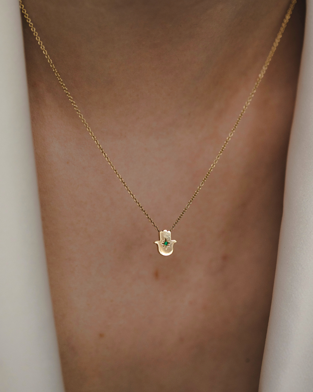 Floating Hamsa gold necklace with Emerald