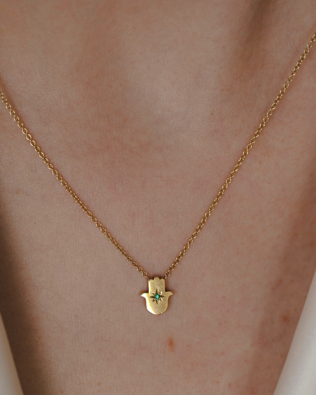 Floating Hamsa gold necklace with Emerald